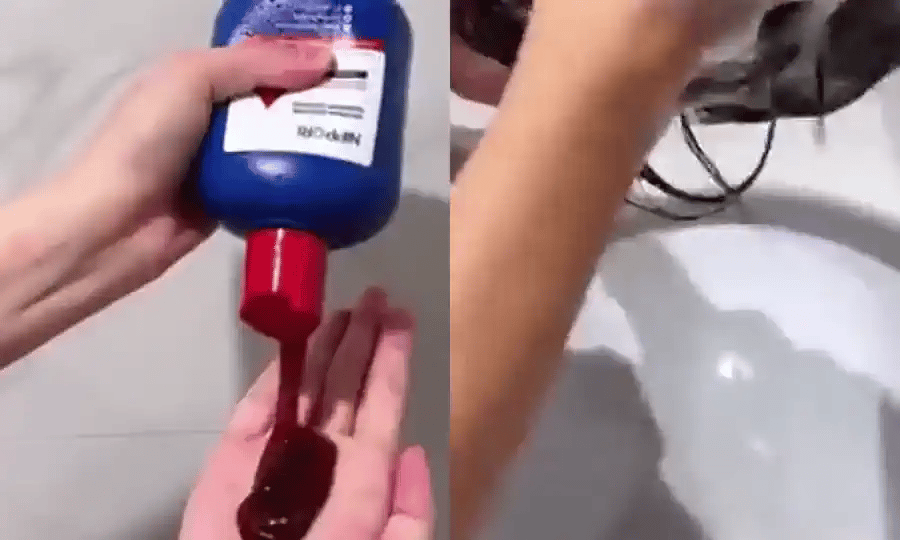 El shampoo servido en la mano desde el frasco azul y el lavado en el lavamanos